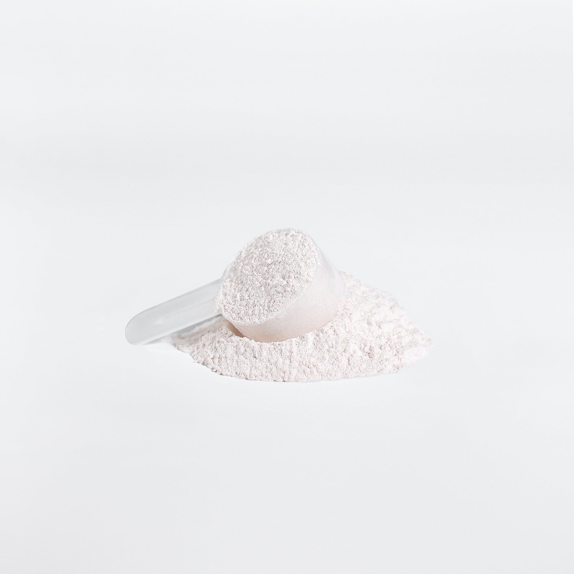 White scoop with powder on a white background