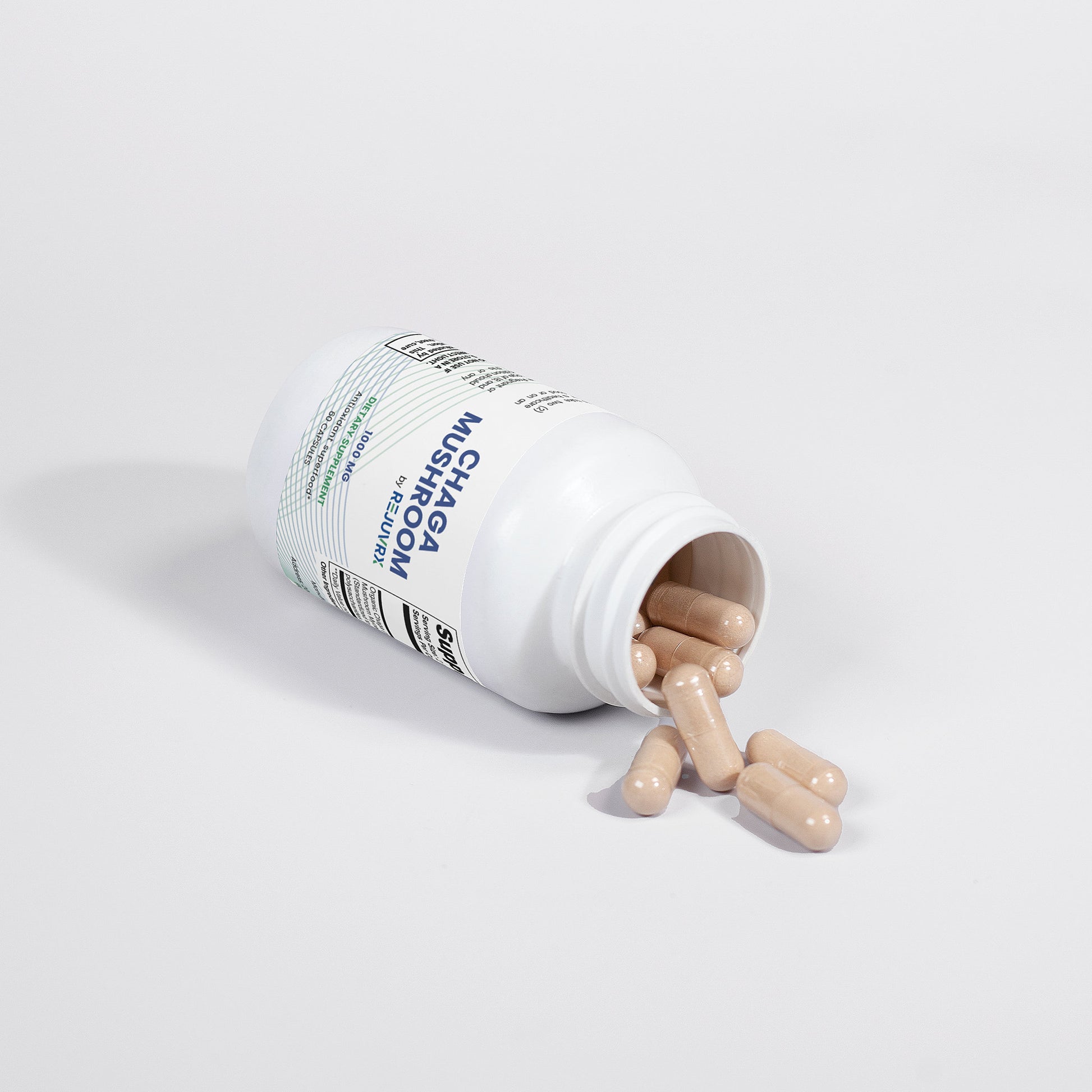 Supplement bottle with pills spilling out on a white background