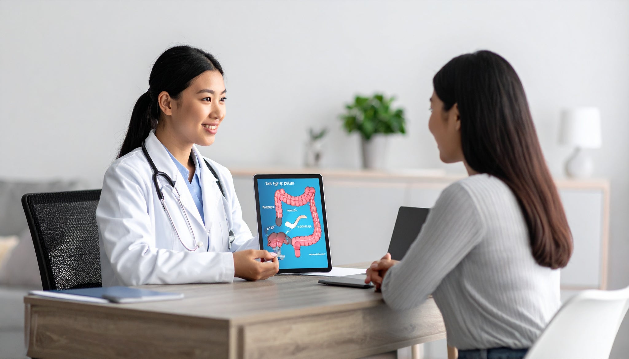 Doctor and patient discussing a digital tablet showing a colon health diagram.