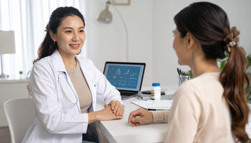 Doctor in a white coat talking to a patient in a medical office.
